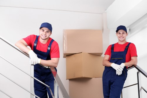 Professional movers carrying furniture from a flat in Islington